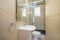 Full bathroom with white porcelain sink and shower in the back,