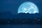 full Beaver Moon back on mountain and reflection on river in the night sky