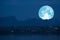 full Beaver Moon back on mountain and reflection on river in the night sky