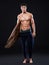 Full body - fit body. Full length studio shot of a young surfer with a vintage board.