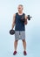 Full body length shot active and sporty senior man lifting dumbbell. Clout