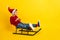 Full body photo of adorable small schoolboy sled have fun winter vacation stylish red knitted clothes isolated on yellow