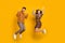 Full body photo of brown haired man and woman excited winner raise fists success jump isolated on yellow color