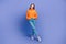 Full body photo of candid lady posing in her best look put hands in pockets with orange knit jumper  on violet