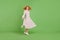 Full body photo of charming happy young lady spin wind fly skirt isolated on vibrant green color background