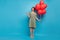 Full body photo of cheerful dreamy young woman point finger empty space sale news balloons isolated on blue color