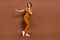 Full body photo of cheerful positive woman dance rest free time cool isolated on brown color background