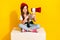 Full body photo of cute small girl sit white cube point loudspeaker wear trendy white clothes isolated on yellow color