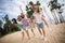 Full body photo of excited crazy group friends walking sand beach piggyback spend pastime outdoors