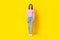 Full body photo of gorgeous cute young girl standing straight front view wear trendy striped look isolated on yellow