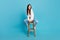 Full body photo of gorgeous lovely lady sitting stool look empty space isolated on blue color background