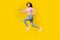 Full body photo of gorgeous young lady excited running fast hurry sales dressed trendy striped outfit isolated on yellow