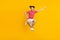 Full body photo of happy joyful young raise hand super hero jump up summer isolated on yellow color background