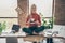 Full body photo of happy positive woman company owner sit on table crossed legs rest relax hold coffee cup drink