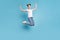 Full body photo of jumping lady carefree mood wear white casual t-shirt jeans denim  blue background