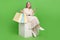 Full body photo of lovely retired lady sit cube shopping bags device dressed stylish white outfit isolated on green