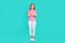 Full body photo of nice teen woman folded hands confident pose wear trendy print pink clothes  on cyan color