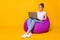 Full body photo of positive cheerful girl sit violet bag armchair use computer read e-book wear white t-shirt footwear