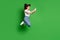 Full body photo of positive girl jump use cellphone wear white jeans isolated over bright green color background