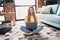 Full body photo of teenager barefoot girl using netbook when learning it courses sitting floor isolated on home