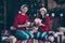 Full body photo of two romantic spouses people sit on plaid blanket hold packages for christmas x-mas celebration in