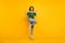 Full body photo of victorious happy woman raise fists yeah jump up wear shoes isolated on shine yellow color background