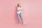 Full body photo of youg attractive woman happy positive smile folded hands look empty space isolated over pink color