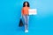 Full body photo of young afro woman happy smile shopping store advertise discount poster isolated over blue color