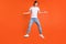Full body photo of young clueless man jump up shrug shoulders no idea isolated on orange color background