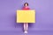 Full body photo of young excited woman happy positive hold poster billboard ad amazed surprised isolated over violet