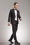 Full body picture of an elegant man in tuxedo walking