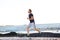 Full body portrait of active man running by beach