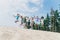 Full body portrait of excited active buddies jumping hold arms have fun sand beach outdoors