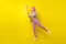 Full body profile photo of cool pink hairdo millennial lady hold net wear shirt jeans sneakers isolated on yellow