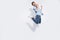 Full body profile photo of funny arabian guy jumping high rejoicing of great win raising fists wear casual denim shirt