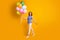 Full body profile photo of funny foxy lady hold many colorful balloons walk street festive mood party wear polka-dot