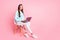 Full body profile portrait of positive person distance work laptop on knees wear sweater  on pink color