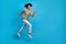 Full body profile side photo of young cheerful man runner hurry fast look empty space isolated over blue color