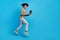 Full body profile side photo of young man jump go use laptop expert marketer active isolated over blue color background