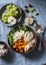 Full bowl with baked sweet potatoes, barley, arugula and apples. Vegetarian buddha bowl with autumn vegetables and grains, on a bl