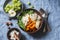 Full bowl with baked sweet potatoes, barley, arugula and apples. Vegetarian buddha bowl with autumn vegetables and grains, on a bl