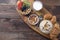 Full Breakfast of oatmeal with nuts, muesli with berries and fruits, croissants and glass of milk on wooden background