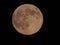 Full brown moon in the black sky at night