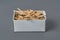 Full cardboard matchbox of many used matchsticks on dark concrete table on kitchen