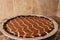 Full chocolate peanut butter pie with earth tone tile background