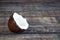 A full coconut lies on a wooden table. White