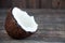 A full coconut lies on a wooden table. White