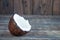 A full coconut lies on a wooden table. White