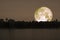 full cold moon back on mountain and reflection on river in the night sky