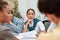 Full concentration. Young asian business woman sitting at business meeting with her coworkers in the modern office